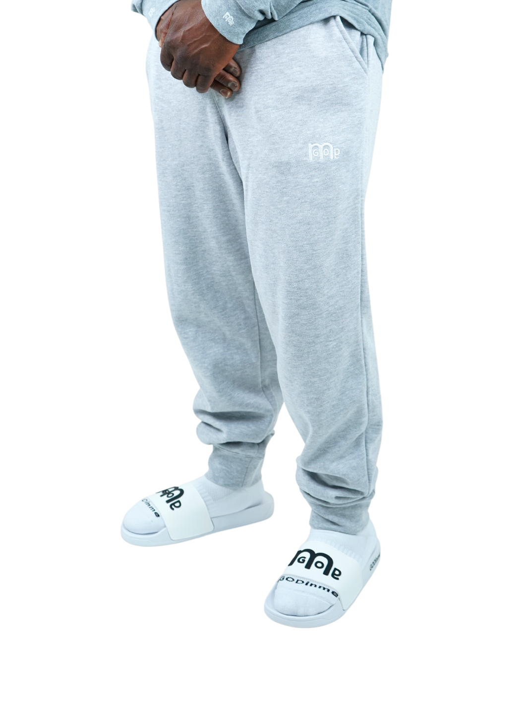 Experience the ultimate comfort in Men's joggers with GODinme! Made with premium quality fabric, these Grey GODinme sweat pants offer an elastic waistband for that perfectly relaxed fit. Featuring ribbing ankle cuffs, sewn eyelets, and the signature GODinme logo (in White) at left leg.