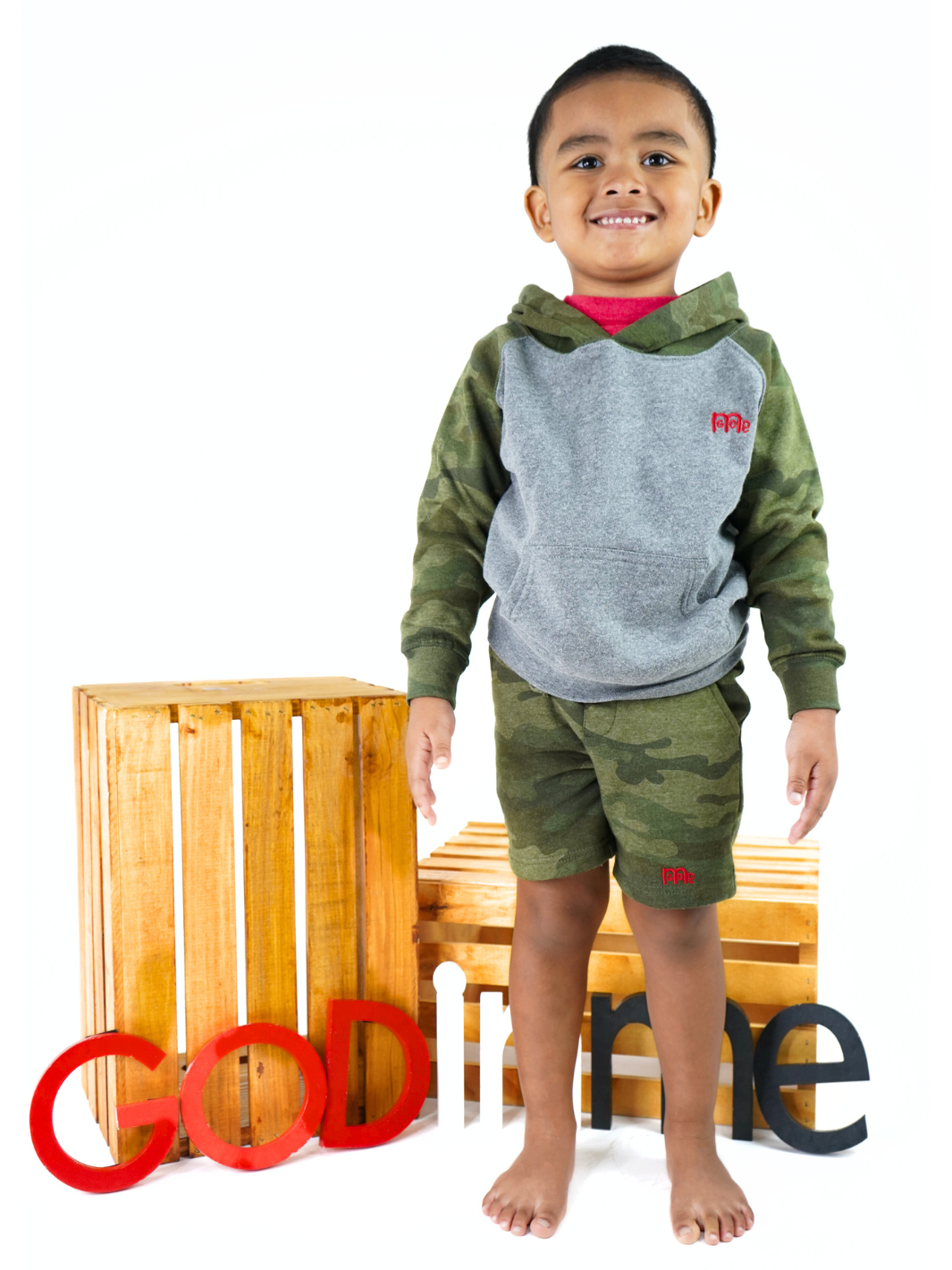 Toddler size Green Camouflage Shorts with elastic waistband, sewn fly detail, jersey-lined front pockets, stylish back pocket, and Red GODinme logo.