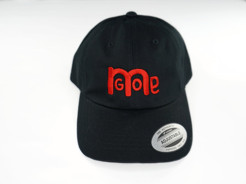 The forever popular Black 6 panel unstructured Dad Hat has Black curved under visor and antique Brass buckle closure. Embroidered in Red is the GODinme Logo on front and GODinme name on left side.