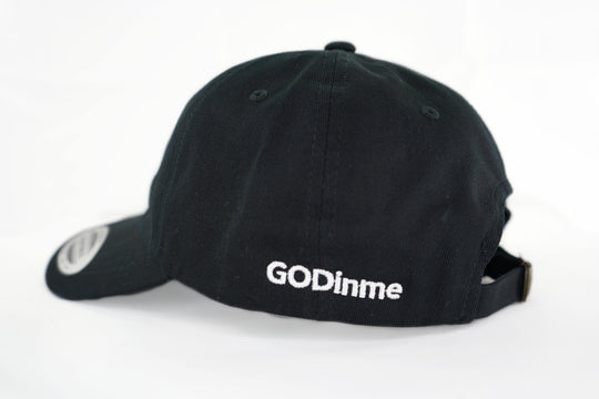 The forever popular Black 6 panel unstructured Dad Hat has Black curved under visor and antique Brass buckle closure.  Embroidered in White is the GODinme Logo on front and GODinme name on left side.